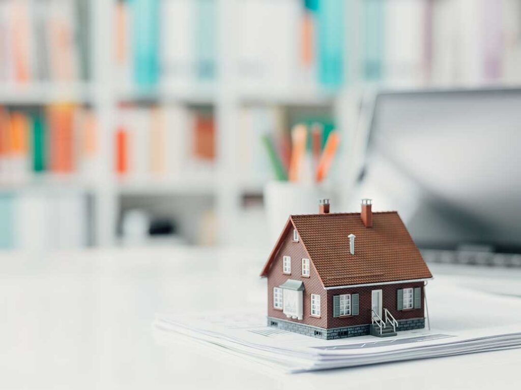 Homeowners review renovation plans beside a bright kitchen with updated cabinets, flooring, and natural light.