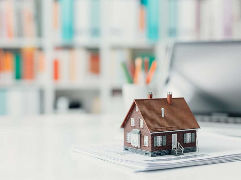 Homeowners review renovation plans beside a bright kitchen with updated cabinets, flooring, and natural light.