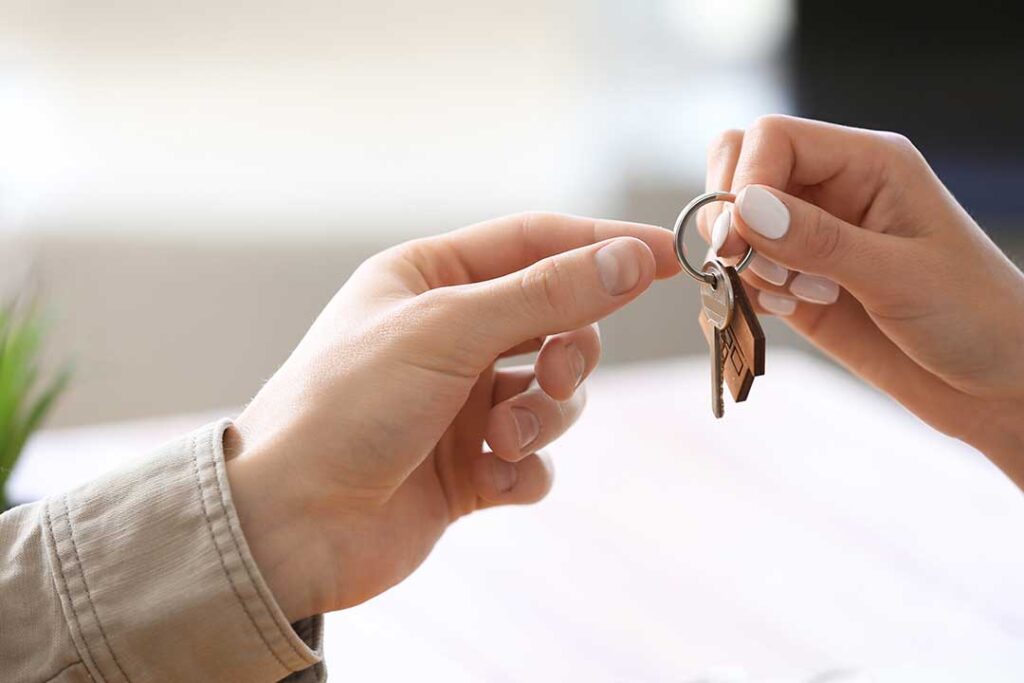 Homebuyer reviewing mortgage documents and a monthly payment worksheet at a kitchen table.