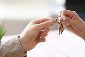 Homebuyer reviewing mortgage documents and a monthly payment worksheet at a kitchen table.